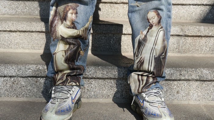 Auf einer Jeans sind Maria und ein Engel abgebildet