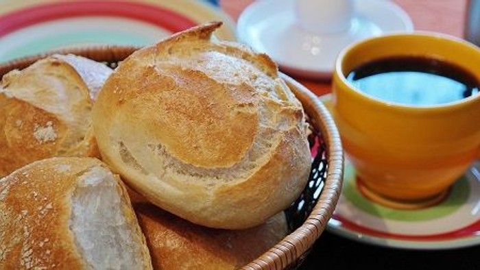 Ein Korb mit frischem Brot und eine Tasse Kaffee