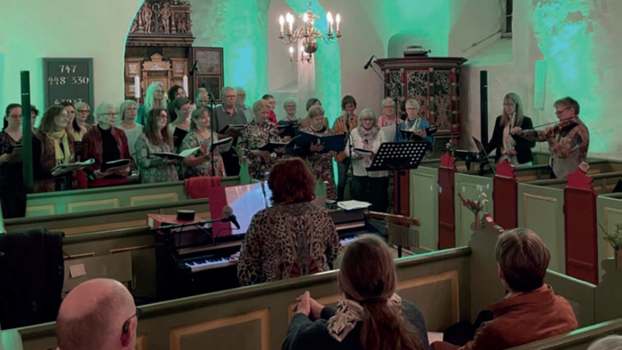 En kirkekor med flere sangere og en pianist under optagelse.