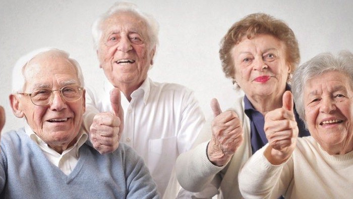 Vier ältere Menschen zeigen Daumen hoch