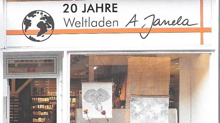 Feierliche Ladenfront mit 20-Jahre-Schriftzug und Globus-Logo