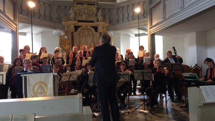 Ein Dirigent leitet einen Chor in einer Kirche