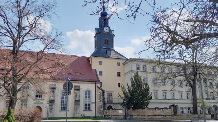 Historische Kirche mit Uhrturm in altem Gebäudeensemble