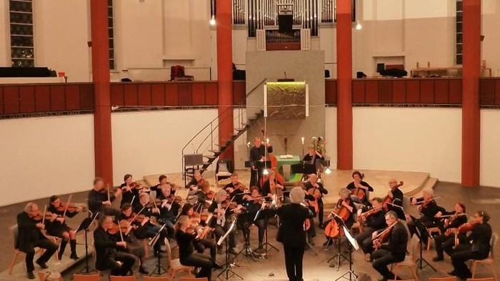 Ein Orchester probt in einer Kirche vor einer Orgel