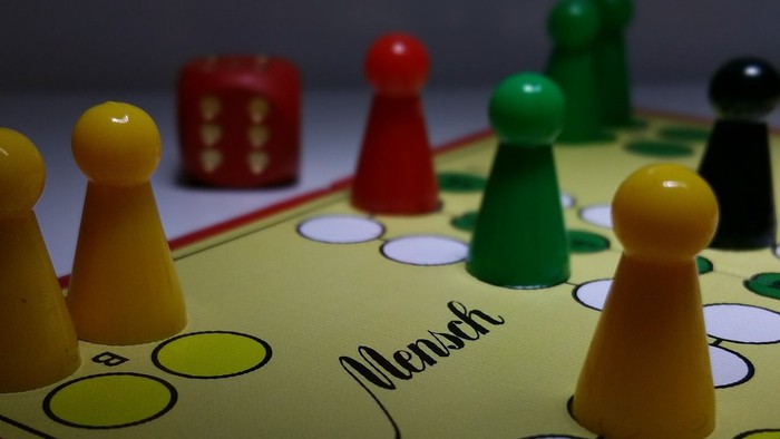 Das Bild zeigt ein Gesellschaftsspiel mit verschiedenen Spielfiguren und einem Spielbrett.