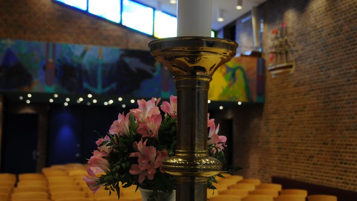 En lysestage med blomster i en kirke