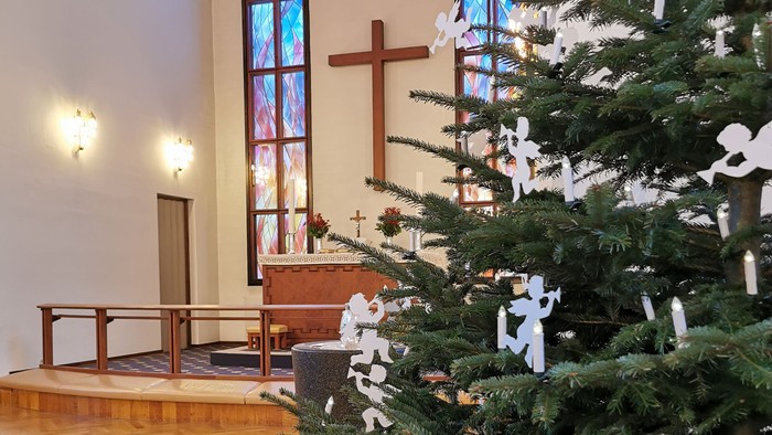 En juletree med hvidt dekoration i kirke.