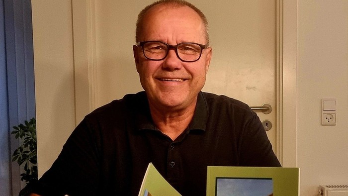 Mand med boger i håndene og et smil