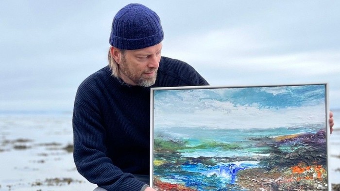 Mand der sidder og kigger på et maleri 