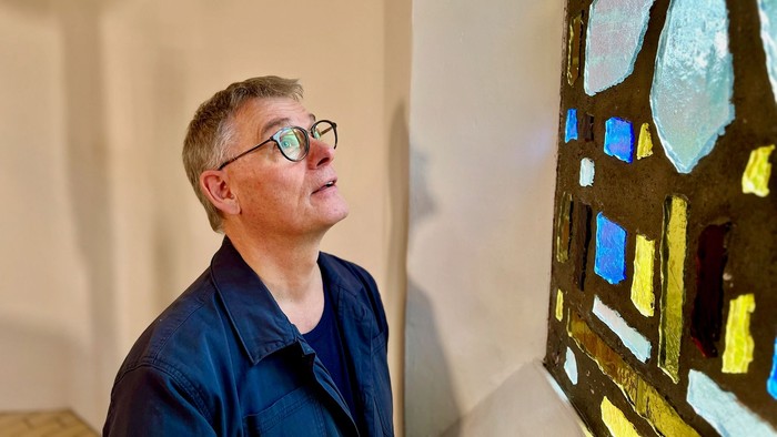 Mand ser opadad til et farverigt glasvindue.