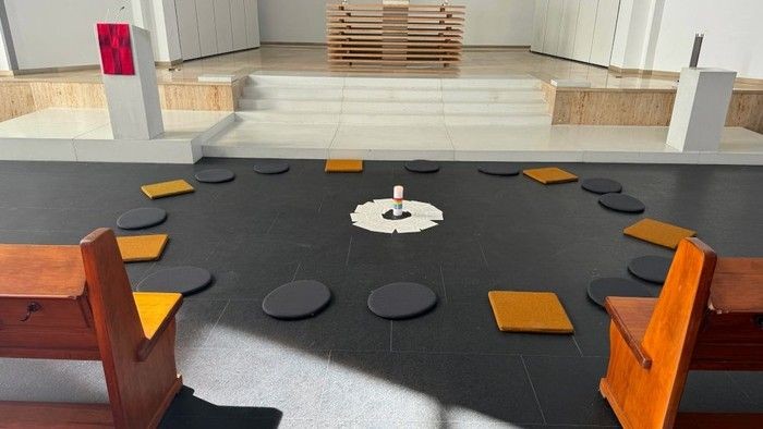 Ein moderner Raum mit einem Kreis aus Sitzkissen und einem Tisch in der Mitte.