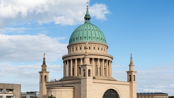 Großartige Kuppelkirche mit grünem Dom vor Stadtpanorama