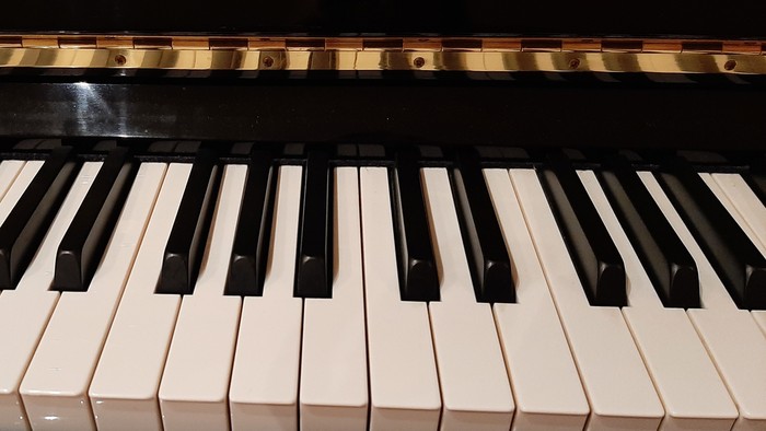 Die Tastatur eines schwarzen Klaviers mit weißen und schwarzen Tasten.