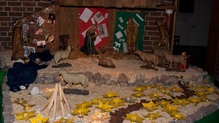 Ein Krippenszene mit verschiedenen Figuren und einer Holzscheune