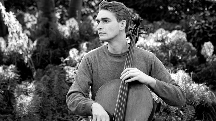 En ung mand spiller cello i en træge omgivelse