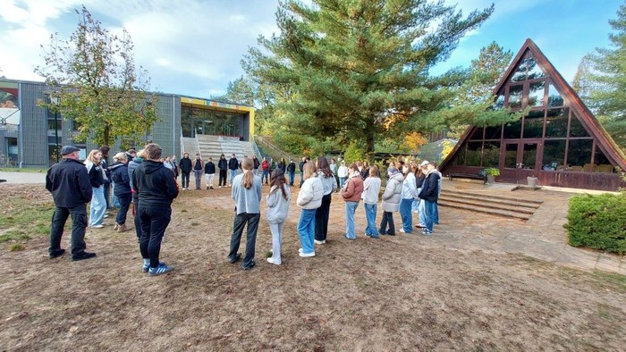 Ein Gruppe Jugendlicher steht vor einer Kapelle