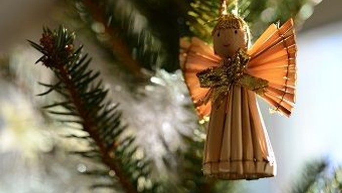 En juledekorationsengel hænger på et træ.