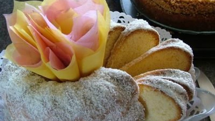 Zwei Kuchen mit Puderzucker und Blumendekoration auf einem Teller