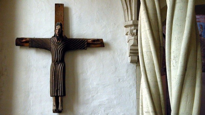 Ein hölzernes Kruzifix an einer weißen Wand