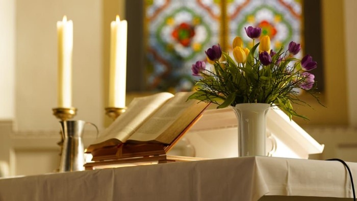 Altartisch mit Blumen, Bibel und Kerzen