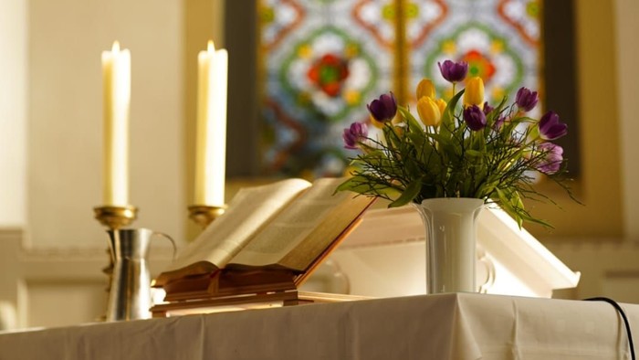 Altartisch mit Blumen, Bibel und Kerzen