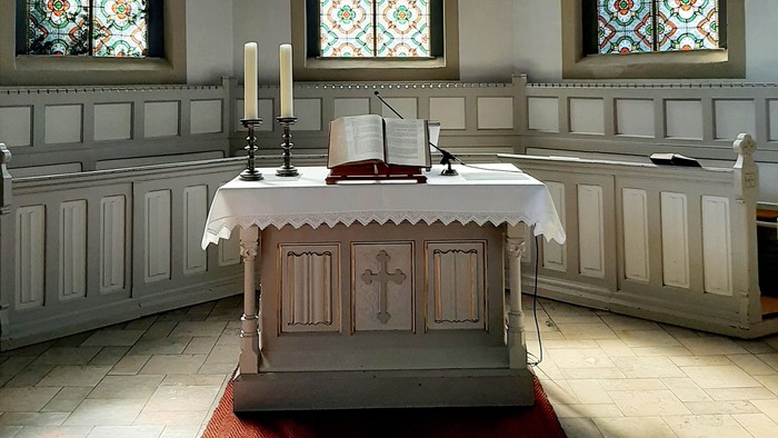 Innenraum Kirche, Altar mit Kerzen und Bibel 