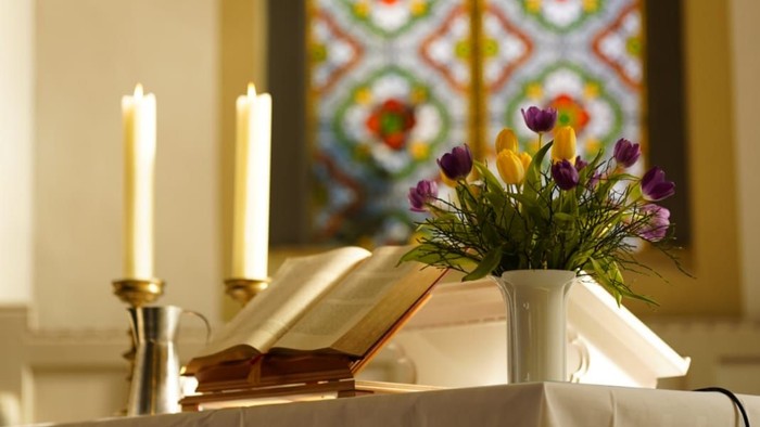 Altartisch mit Blumen, Bibel und Kerzen