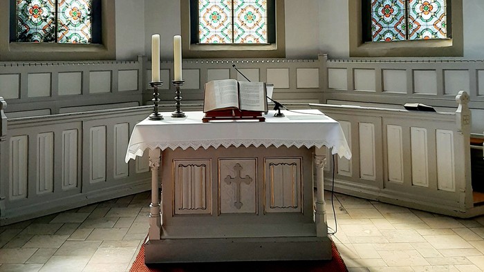 Innenraum Kirche, Altar mit Kerzen und Bibel 