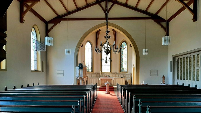 Kirchenraum, Bänke, roter Teppich, Altarraum mit Taufbecken