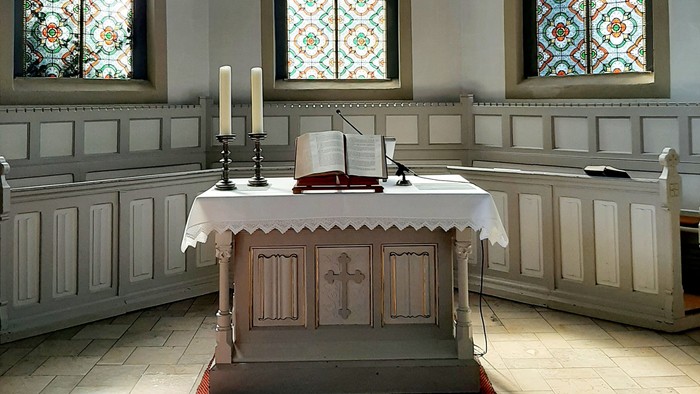 Innenraum Kirche, Altar mit Kerzen und Bibel 