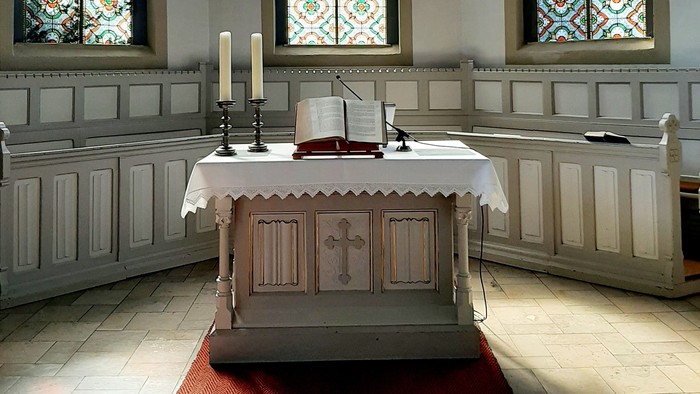 Innenraum Kirche, Altar mit Kerzen und Bibel 