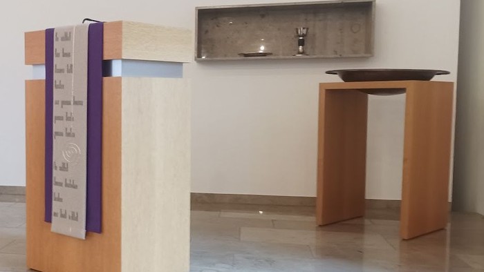 Ein hölzerner Pult und Tisch vor einer weißen Wand