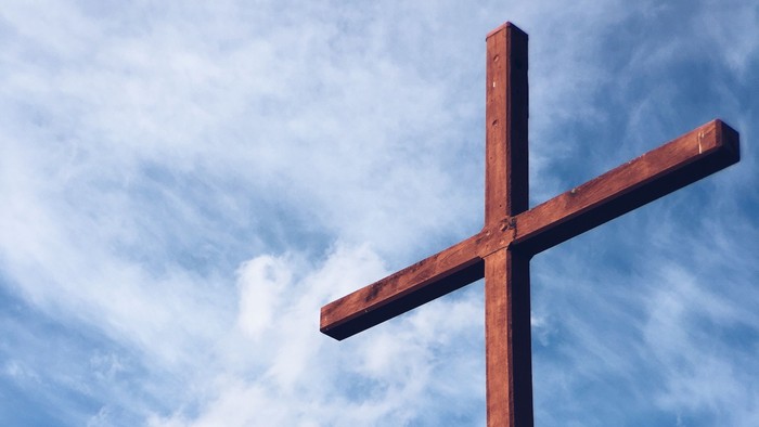 Ein hölzernes Kreuz vor einem bewölkten Himmel