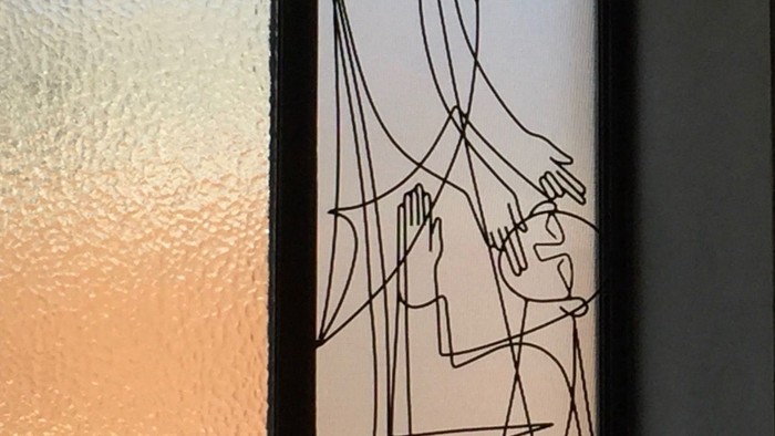Ein Fenster mit abstrakter Zeichnung und Kerze davor