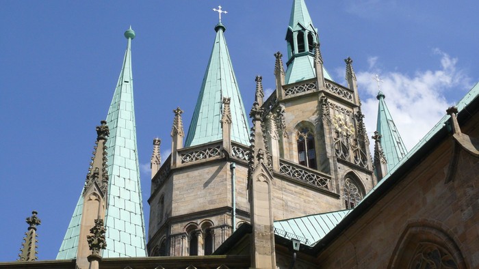 Gotische Kirche mit grünen Spitzen und Kreuz auf dem Turm