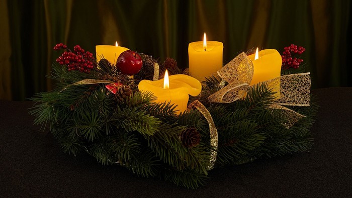 En juledekorasjon med lysende lygter, grønne nødder og bær til advent.