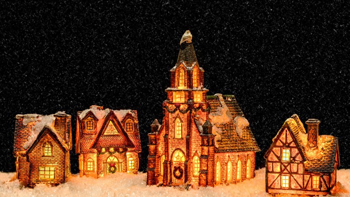 Lille bymodel med kirke og huse i sne.
