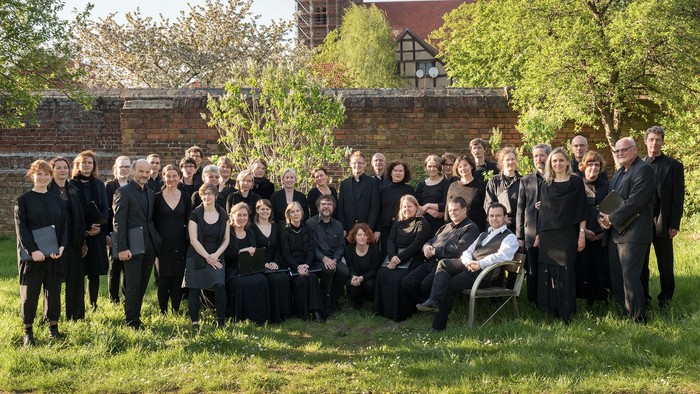 Eine Gruppe von Menschen in Schwarz posiert gemeinsam im Freien für ein formelles Gruppenfoto.