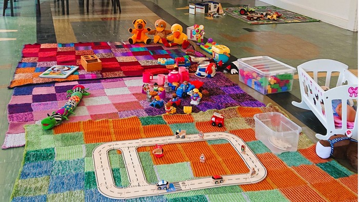 Legetøj på buntapet på guldbetonede gulve i et leje.