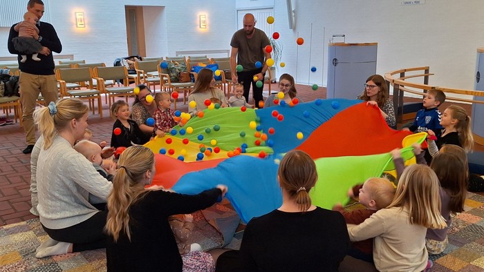 Børn spiller med farverige paraply på børnefestival