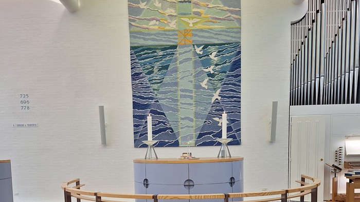 En udstilling med blå og gule farver, der minder om havet og en lille by.