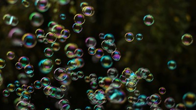 Farbenfrohe Seifenblasen schweben im Dunkeln