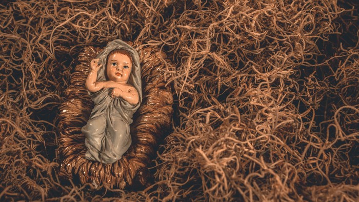 Ein Baby liegt in einem Korb mit Heu.