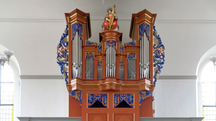 Orgel in Kirche mit farbenfroher Dekoration und Holzgehäuse