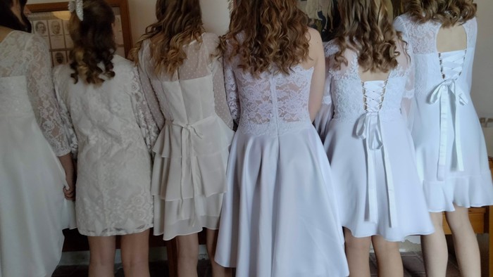 En gruppe piger står i en kred, alle med lange hår og smukke kvinder.