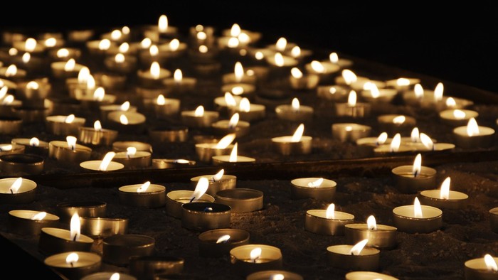 Viele brennende Kerzen in dunkler Umgebung