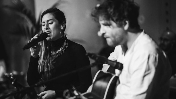 Ein Mann und eine Frau, die gemeinsam Musik machen – er spielt Gitarre und sie singt.