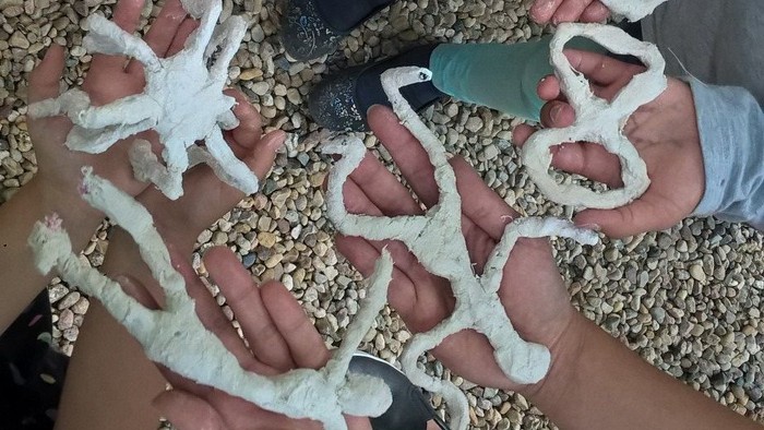 Kinder zeigen selbstgemachte Tonfiguren