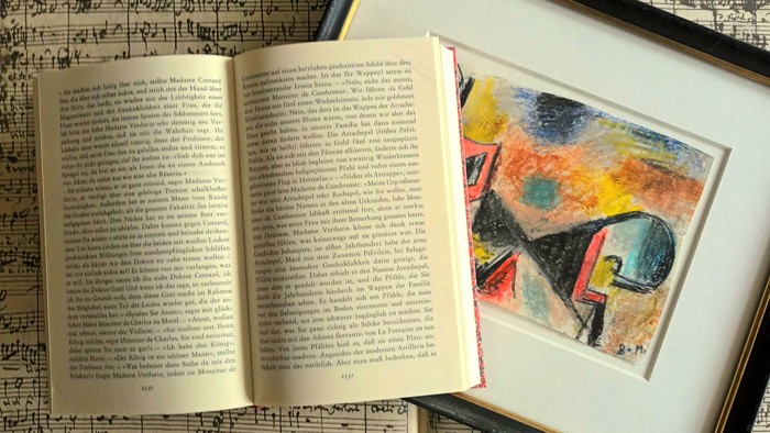 Ein aufgeschlagenes Buch liegt neben einem gerahmten abstrakten Gemälde auf Notenblättern