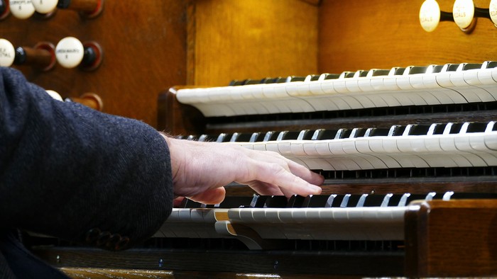 Person spielt Orgel in Kirche